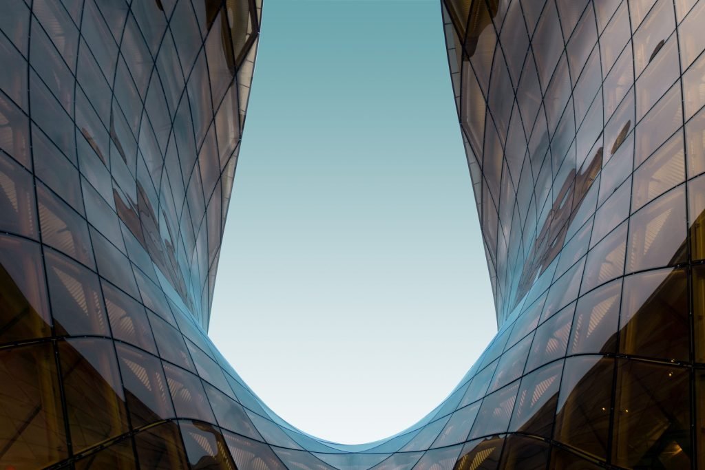 glass u shaped structure with blue sky